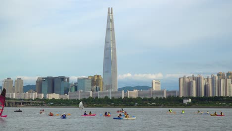 Local-Tourists-Having-Fun-At-Han-River-With-Water-Sports-Activities-And-View-Of-Lotte-Tower-In-City-Of-Seoul,-South-Korea