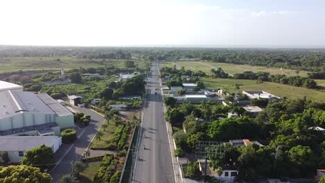 static-drone-shot-of-drone-overhead-moving-along-long-highway-with-little-traffic-on-the-roadside,-rural-environment