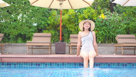 Fashionable-Exotic-Woman-on-Poolside-of-Luxury-Hotel,-Bathing-Legs-in-Water,-Full-Frame-Slow-Motion