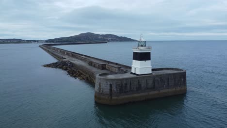 Holyhead-breakwater-lighthouse-longest-concrete-coastal-sea-protection-landmark-aerial-view-low-wide-right-rotation