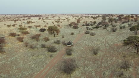 A-4x4-Safari-Vehicle-Through-Savannah-Of-Namibian-Deserted-Landscape-In-Southern-Africa