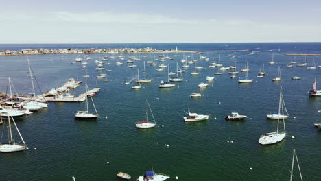 Aerial-Footage-of-Scituate-Harbor,-Low-Long-Pullback-with-drone,-showing-moored-yachts,-open-ocean-in-distance