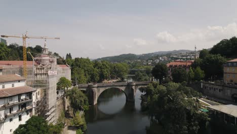 Town-of-Amarante-with-majestic-medieval-bridge-and-town-buildings,-aerial-fly-over-view
