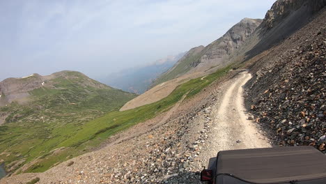 Rooftop-view-of-driving-on-Black-Bear-Pass-trail-cut-into-a-steep-and-rock-mountainside-high-above-Mineral-Creek-Basin-near-Telluride-Colorado