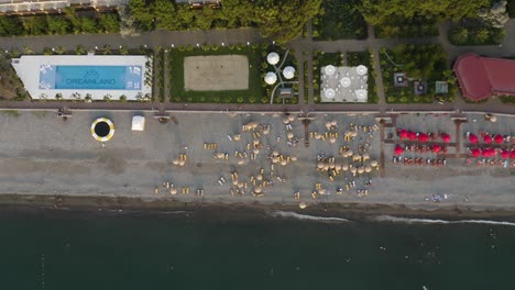 Top-View-Of-Waterfront-Hotel-And-Resort-With-Parasols-On-Sandy-Beach