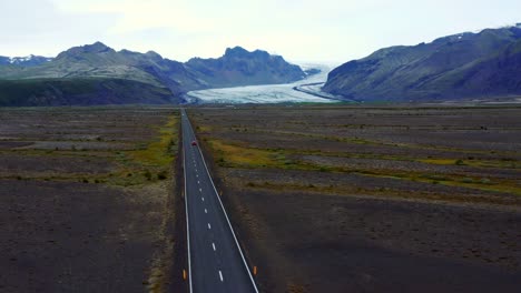 Autofahren-Auf-Asphaltierter-Straße-Mit-Svinafellsjökull-Gletscher-In-Der-Ferne-In-Svinafell,-Island
