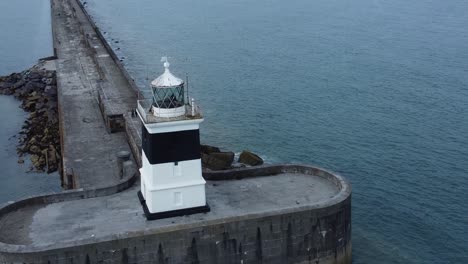 Holyhead-breakwater-lighthouse-longest-concrete-coastal-sea-protection-landmark-aerial-view-slow-rotating-right