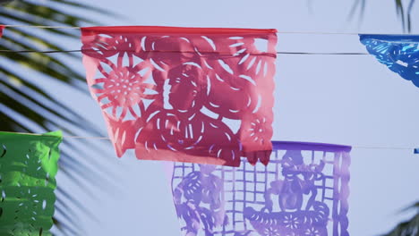 Mexican-Papel-Picado-Paper-Festival-Banner-blows-in-wind,-slow-motion