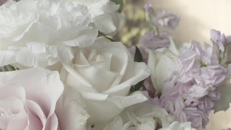 Close-up-of-floral-arrangement-on-table-where-wedding-guests-are-received