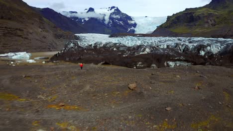 Tourists-Watching-Svinafellsjokull-Glacier-In-Skaftafell-National-Park,-Iceland---aerial-drone-shot