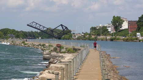 A-man-walking-on-a-pier-separating-the-Niagara-River-and-the-Erie-Canal