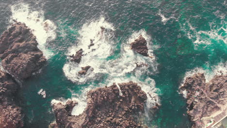 Overhead-view-of-waves-splash-on-rocks