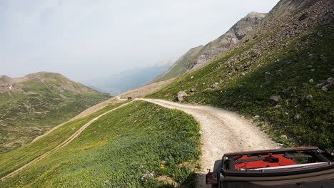 View-of-the-sunroof-of-4WD-vehicle-traversing-along-a-narrow-trail-across-very-steep-alpine-meadow-near-Black-Bear-Pass-in-San-Juan-Mountains-of-Colorado