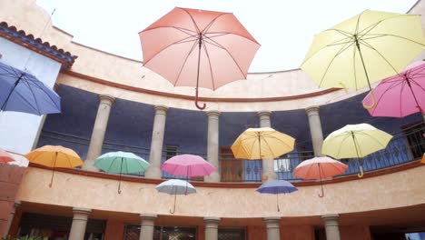 Colorful-umbrellas-hanging-in--courtyard-in-spain