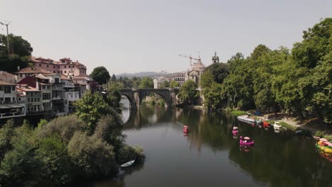 Beautiful-cityscape-with-old-medieval-stone-bridge-of-Amarante-town,-aerial-drone-view