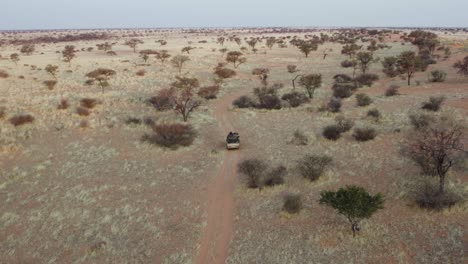 Off-road-Vehicle-Driving-At-The-Road-Amidst-The-Wilderness-In-Namibia,-Africa