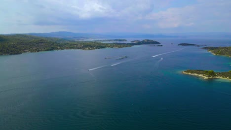 Stetiger-Drohnenclip-über-Einer-Bucht-Mit-Kristallklarem-Wasser-Und-Exotischen-Inseln-In-Vourvourou,-Chalkidiki,-Nordgriechenland-In-4k