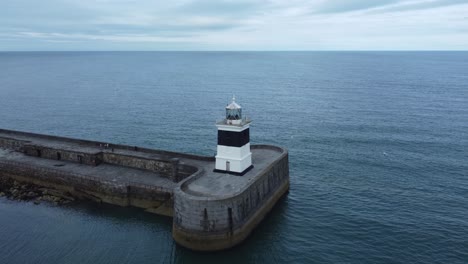 Holyhead-breakwater-lighthouse-longest-concrete-coastal-sea-protection-landmark-aerial-slow-left-rotating-view