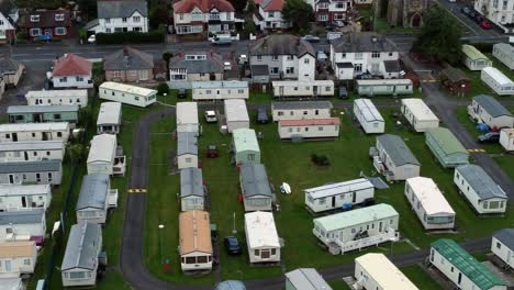 Static-caravan-trailer-beachfront-staycation-holiday-home-campground-resort-aerial-view-dolly-right-birdseye