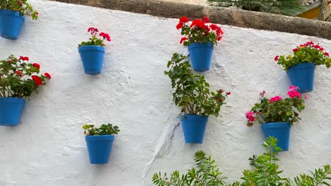 Typische-Spanische-Straße-In-Der-Altstadt-Von-Marbella-Mit-Schönen-Traditionellen-Blauen-Blumentöpfen,-Die-An-Einer-Weißen-Wand-Hängen