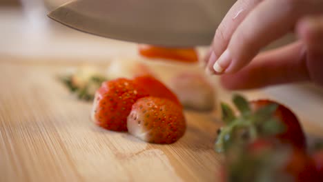 Female-Hands-Cutting-Fresh-Ripe-Strawberries-On-Chopping-Board