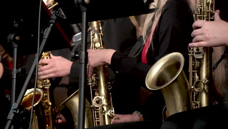 Cerca-De-Mujer-Músico-Tocando-La-Trompeta-Y-El-Saxofón-En-El-Escenario