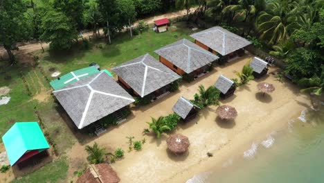 Cinematic-shot-,-ascending-aerial-drone-view-of-a-resort-on-the-coast,-white-sand-beach,-bungalows-in-Roxas,-Palawan