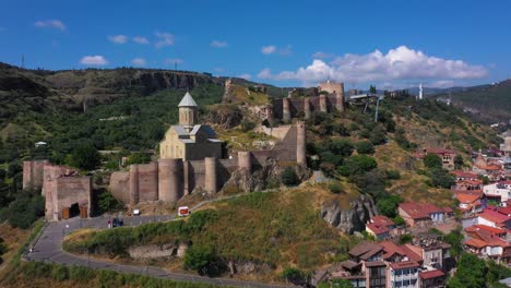 Aerial-arc-shot-of-Narikala-Fortress,-walled-building-in-Tbilisi-Georgia-capital