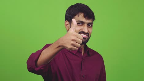 Attractive-man-showing-strong-thumbs-up-while-isolated-on-green-screen
