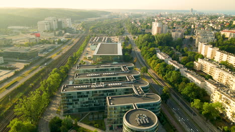 Aerial-backwards-shot-of-ppnt-building-and-Gdynia-Cityscape-in-background-during-sunset
