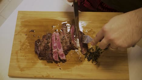 Medium-Rare-A4-Wagyu-Steak-Being-Cut-On-Wooden-Chopping-Board-With-Thyme-On-The-Side