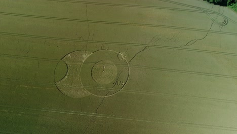 Wootton-rivers-Wiltshire-paranormal-crop-circle-pattern-in-green-farmland-field-aerial-drone-view-rotating-top-down-shot
