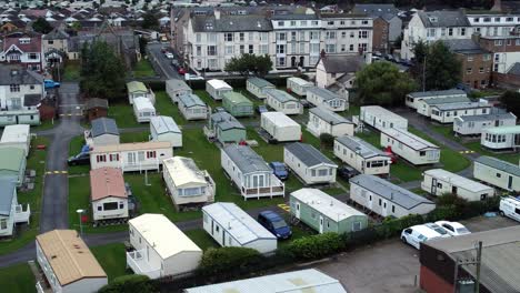 Static-caravan-trailer-beachfront-staycation-holiday-home-campground-resort-aerial-view-zoom-out