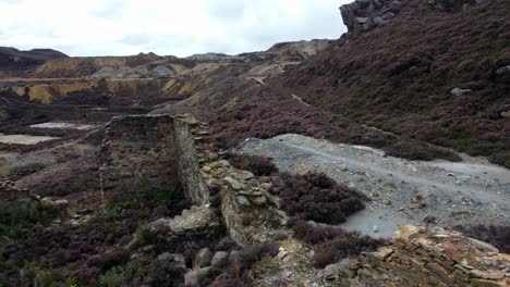 Parys-mountain-rocky-copper-mining-stone-excavation-quarry-ruin-aerial-low-forward-view-Anglesey-mine-Wales-UK