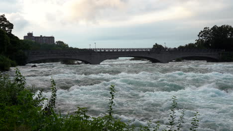 Ein-Blick-Auf-Eine-Brücke-über-Die-Stromschnellen-Am-Niagara-River-Direkt-über-Den-Niagarafällen