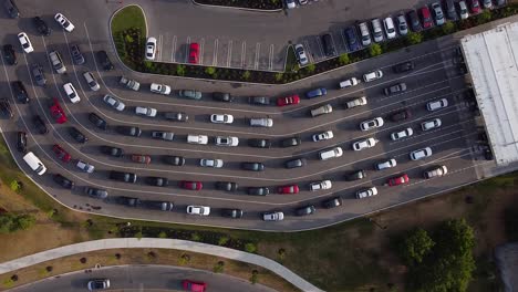 Drone-top-down-shot-of-cars-and-vehicles-lined-up-at-busy-gas-station-to-pump-fuel-during-pandemic-shortage:-4K