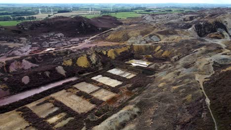 Parys-mountain-abandoned-historic-copper-mine-red-stone-mining-industry-landscape-aerial-view-Birdseye-left-dolly