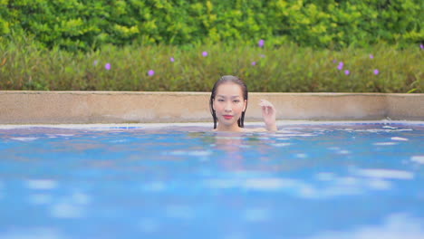 Face-close-up-of-Young-Asian-Woman-in-Her-30th-Walking-Inside-the-Swimming-Pool-Water-with-Just-Head-out-from-the-water