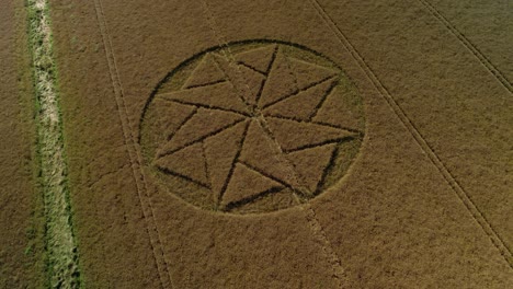 Extraterrestrial-farmland-crop-circle-geometry-artwork-Stanton-St-Bernard-aerial-view-Wiltshire-tilt-down-drone-shot