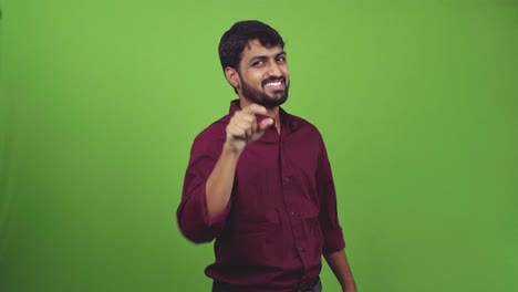Person-showing-gesture-everything-perfect-and-pointing-toward-camera,-isolated-on-green-screen