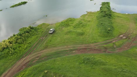 Aerial-footage-of-a-truck-moving-towards-the-edge-of-the-lake,-Muak-Klek,-Saraburi,-Thailand