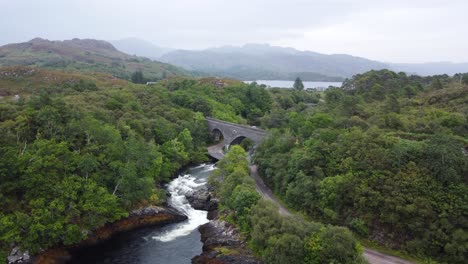 Bridge-over-Morar-River-Waterfall,-West-Coast-of-Scotland---Aerial-Drone-4K-HD-Lower-Reveal