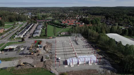 Construction-Site-With-Excavator-and-Crane,-Aerial-Fast-Orbiting-in-Nordic-Country