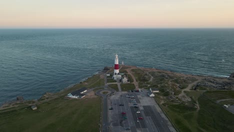 4K-footage-of-a-drone-flying-slowly-towards-the-Portland-Bill's-lightouse,-an-island-in-Dorset,-England,-and-then-goes-over-it,-during-the-sunset