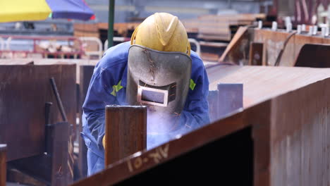 Manual-Worker-In-Welding-Mask-While-Fabricating-Rusted-Steel-Outdoor