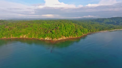 Backward-Flying-Aerial-of-Wild-Jungle-Coiba-Island-Waterfront-Rocky-Shoreline