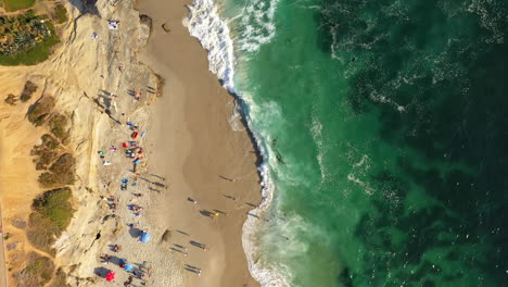 Top-down-aerial-of-San-Diego,-La-Jolla-beach,-with-people-and-surfers