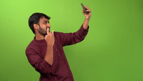 Handsome-man-taking-selfy-with-smartphone,-isolated-on-green-screen