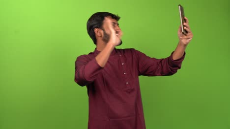 Handsome-man-calling-and-talking-with-friends-on-smartphone,-isolated-on-green-screen