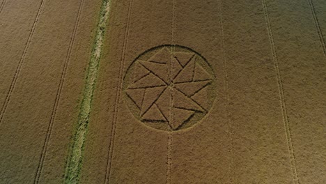 Wheat-harvest-crop-circle-farmland-symbol-aerial-tilt-up-pull-back-view-Stanton-St-Bernard-Wiltshire